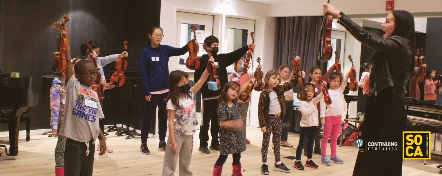UWindsor Lab School: Summer Music Program Students and Instructor lifting up their string instrument